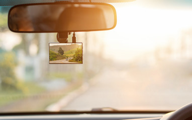 Close up car on highway at sunset, with video recorder next to a rear view mirror,video recorder...