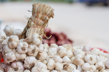 garlic heads, tied up for bulk sale at a local Thai market,
