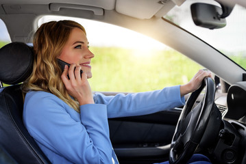 Woman speaks on the phone in the car.