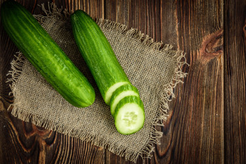Cucumber on dark wooden background.