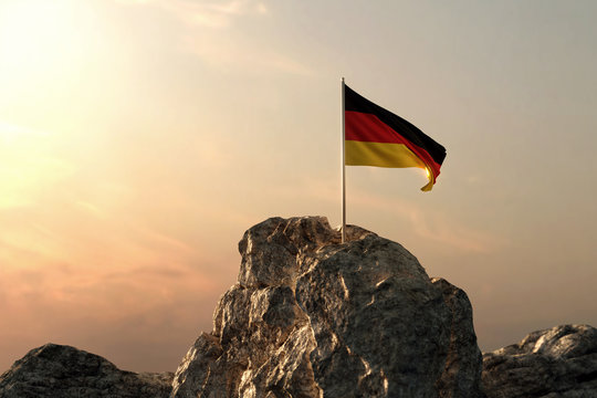 Wehende deutsche Fahne auf Bergspitze im wunderschönen Abendrot