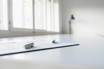Ink pen lying on a contract right next to a signature