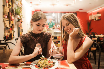 Pretty girls eating pasta