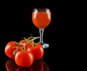 Tomato isolated on a black glossy background with realistic reflection and water drops
