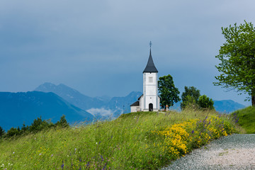 Fototapeta na wymiar Church of St. Primus and Felician, Jamnik Slovenia at stormy weather