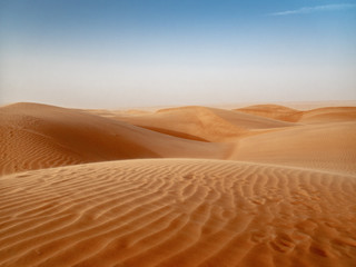 Fototapeta na wymiar The dunes of the Wahiba Sands desert in Oman at sunset during a typical summer sand storm - 4