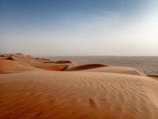 Fototapeta na wymiar The dunes of the Wahiba Sands desert in Oman at sunset during a typical summer sand storm - 3