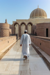 A prayer on his way to the Muscat Grand Mosque in the typical Omani dress early in the morning - 2