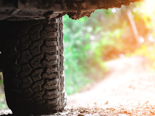 Fototapeta na wymiar Car's wheels on stone in the forest, off-road