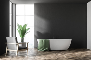Fototapeta na wymiar White tub in a black bathroom, armchair