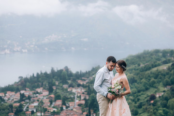 Walking newlyweds in nature. Groom and bride against the background of mountains and the sea.