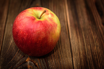 Red apple hazelnut on dark wooden background.