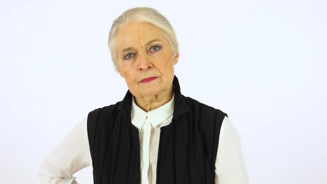 An elderly woman shakes her head at the camera - white screen studio