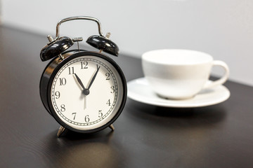 tea time, alarm clock and white mug on the table