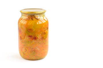 Homemade pickled salad of tomato, pepper, onion and carrot in glass jar isolated on white background.