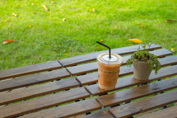 Naklejka premium Iced coffee on a wooden table in the garden.