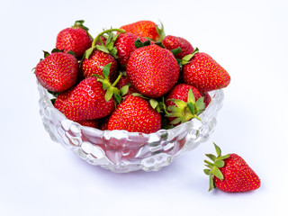 Heap of fresh ripe strawberries in glass bowl on white background, isolated