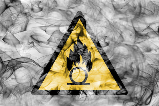 Oxidising materials hazard warning smoke sign. Triangular warning hazard sign, smoke background.