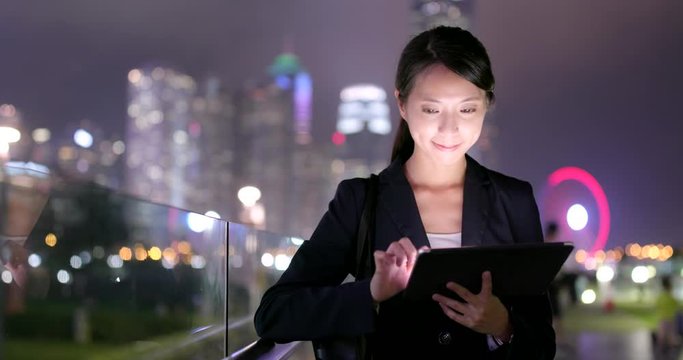 Businesswoman work on tablet computer at night