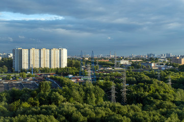 Fototapeta na wymiar Urban landscape in summer, industrial chimneys and high electricity pylons in big city