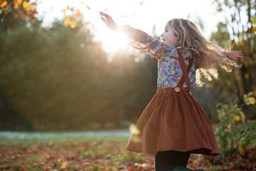 Girl Dancing in a Green Field at Sunset in the Fall