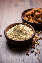 Chick pea flour or Besan powder in a ceramic or wooden bowl along with fried onion pakora or kanda bajji