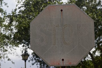 Faded,worn,rusted,sunburned,metal stop sign