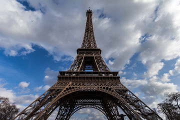 Fototapeta na wymiar Wide angle view of iconic Eiffel tower with dramatic cloudy blue sky in the background.