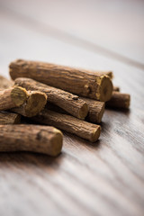 Ayurvedic Mulethi or Liquorice root stick or jeshthamadh powder served in a bowl over moody background