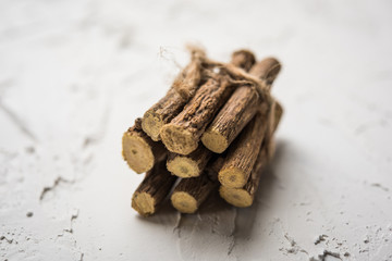 Ayurvedic Mulethi or Liquorice root stick or jeshthamadh powder served in a bowl over moody background