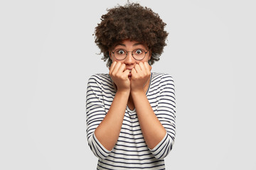 Stressful worried African American female student feels anxious and looks nervously, going to pass graduation final exam at university, isolated over white background. People and feeling concept