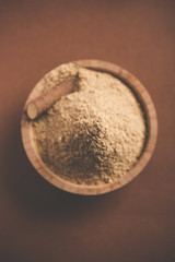 Ayurvedic Mulethi or Liquorice root stick or jeshthamadh powder served in a bowl over moody background