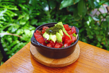Eating a bowl of Hawaiian ahi tuna poke with avocado