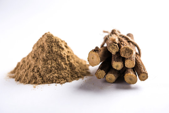 Ayurvedic Mulethi or Liquorice root stick or jeshthamadh powder served in a bowl over moody background