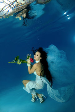 Bride in a wedding  with flowers underwater in the pool. Underwater wedding