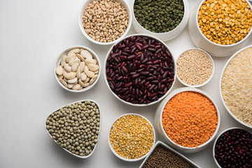 Uncooked pulses,grains and seeds in White bowls over white background. selective focus