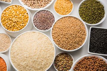 Uncooked pulses,grains and seeds in White bowls over white background. selective focus