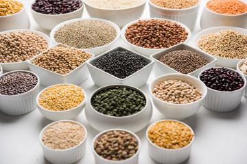 Uncooked pulses,grains and seeds in White bowls over white background. selective focus