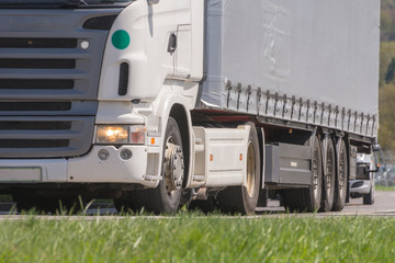 Lkw mit Sattelanhänger beim fahren im Frühling im Güterverkehr