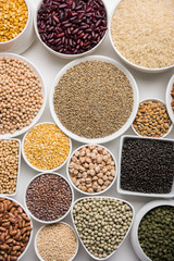 Uncooked pulses,grains and seeds in White bowls over white background. selective focus