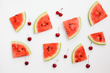 Pieces of watermelon and cherries on a white background