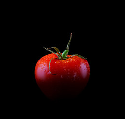 Tomato single with drops isolated on black