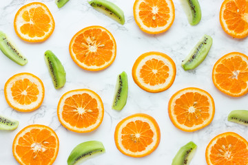 Healthy background orange and kiwi fruit slices on a white background top view