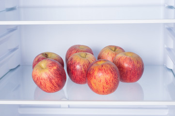 Open fridge, apples on the shelf of refrigerator, healthy nutrition concept