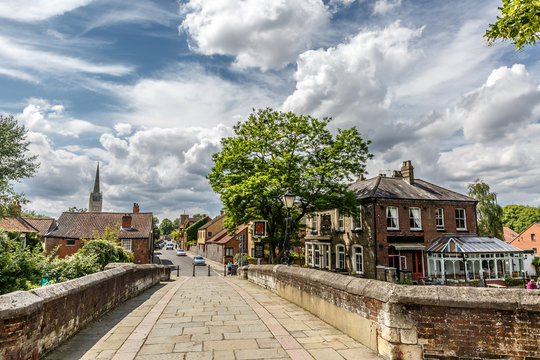Pedestrian crossing through a small bridge of stones and bricks in Norwich