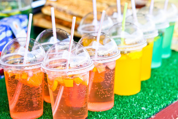 Cold drinks of juice and alcohol in a plastic cup with a tube. Summer holidays and food in nature. Stock Photo