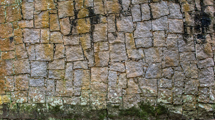 Grunge stone wall with irregular pattern and moss