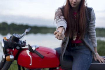 A girl on a motorcycle shows the middle finger