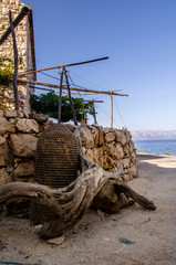 Fototapeta na wymiar corner in dalmatia, view of the seaside in dalmatia, with a old trunk close by a fish cage. croatia, summer.