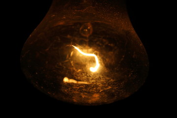An old dusty light bulb. Incandescent lamp. Close-up. Background.